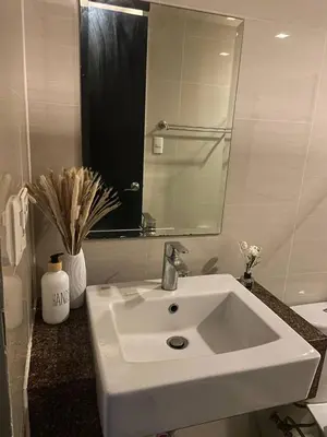 a bathroom with a white sink and a mirror at Estancias De Sofielo in Manila