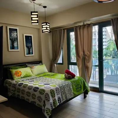 a bedroom with a green and white bed and windows at LDN Secret Crib 3P - Two Palm in Manila
