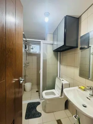a bathroom with a toilet and a sink at Palm Beach West - Baler Tower in Manila