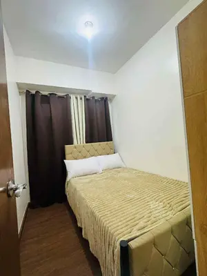 a small bedroom with a bed and a window at Palm Beach West - Baler Tower in Manila