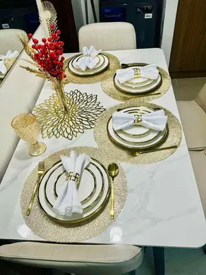 a table with gold and white plates and napkins at Palm Beach West - Baler Tower in Manila