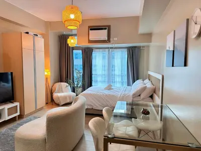 a bedroom with a bed and a glass table at Kozy Mood Studio in Manila