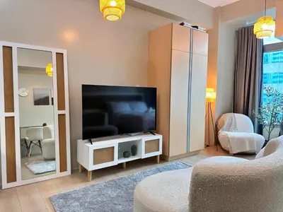a living room with a flat screen tv on a stand at Kozy Mood Studio in Manila