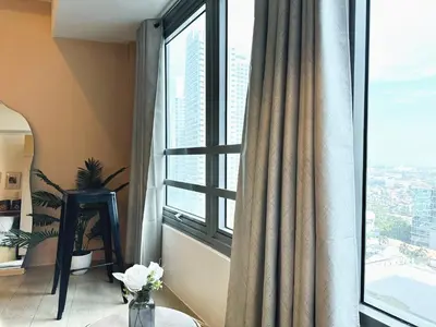 a room with a window with a vase of flowers at Kozy Mood Studio in Manila