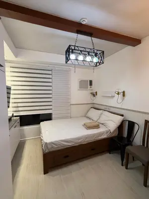 a bedroom with a bed and a window and a chair at Flat 316 Modern Minimalist Studio Near Makati BGC in Manila