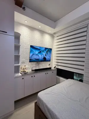 a bedroom with a bed and a flat screen tv at Flat 316 Modern Minimalist Studio Near Makati BGC in Manila