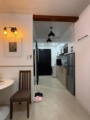 a kitchen with a table and a chair and a refrigerator at Flat 316 Modern Minimalist Studio Near Makati BGC in Manila