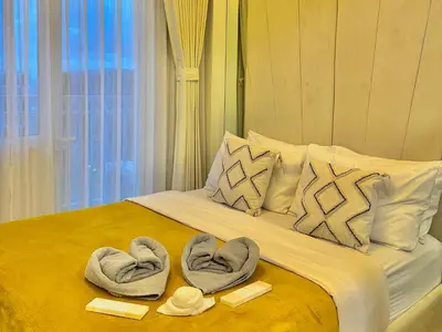 a bed with towels on top of it with a window at Golden Sunset Suite in Manila