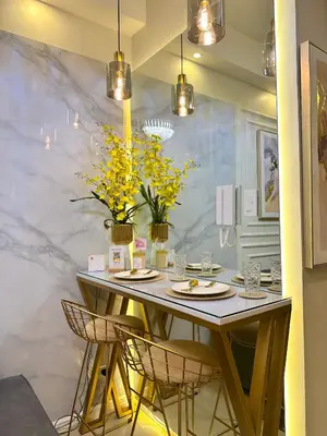 a dining room table with chairs and yellow flowers at Golden Sunset Suite in Manila