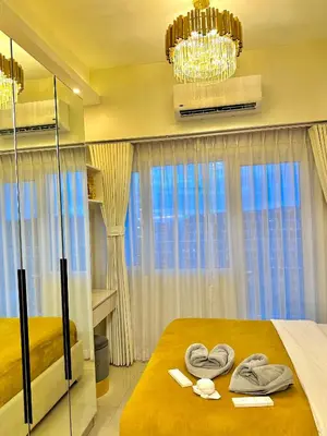 a bedroom with a bed with towels on it at Golden Sunset Suite in Manila