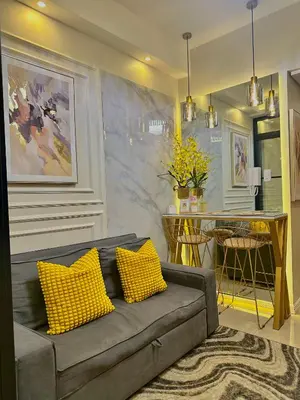 a living room with a couch with two yellow pillows at Golden Sunset Suite in Manila