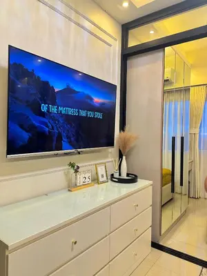 a living room with a flat screen tv on a wall at Golden Sunset Suite in Manila