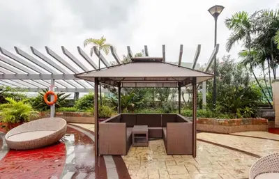 a patio with a table and chairs and a large umbrella at Spectacular Penthouse with Stunning Balcony in Eastwood Mall in Manila