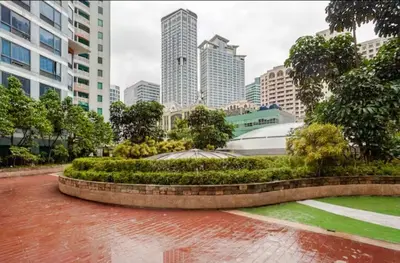 a park in the middle of a city with tall buildings at Spectacular Penthouse with Stunning Balcony in Eastwood Mall in Manila