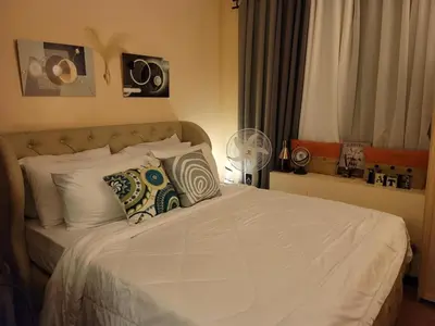 a bedroom with a large white bed with two pillows at Spectacular Penthouse with Stunning Balcony in Eastwood Mall in Manila