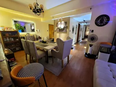 a dining room and living room with a table and chairs at Spectacular Penthouse with Stunning Balcony in Eastwood Mall in Manila