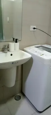 a bathroom with a white sink and a counter at Like home staycation in Manila