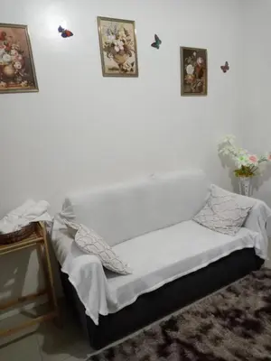 a bed in a room with two pictures on the wall at Like home staycation in Manila