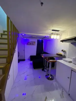 a purple room with a table and a couch at Elegant Golden Loft with Mood Lighting Central Location and Skyline Views in Manila