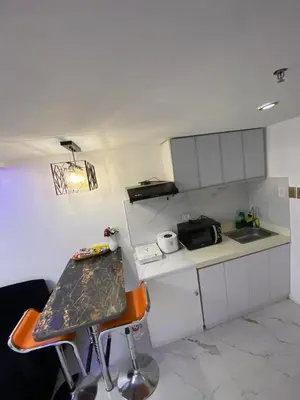 a small kitchen with a table and a counter top at Elegant Golden Loft with Mood Lighting Central Location and Skyline Views in Manila