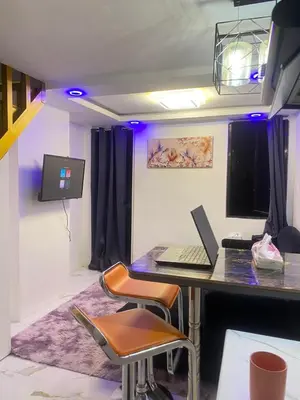 a room with a desk with a laptop on it at Elegant Golden Loft with Mood Lighting Central Location and Skyline Views in Manila