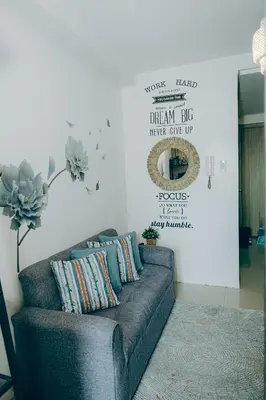 a couch in a living room with a sign on the wall at Budget staycation near moa in Manila