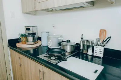 a kitchen with a counter top with a stove with at Budget staycation near moa in Manila