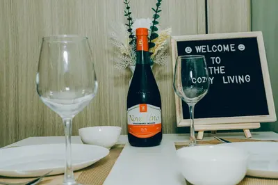 a bottle of wine sitting on a table with two glasses at Budget staycation near moa in Manila