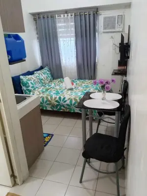 a small room with a table and a bed at Zafreen Condotel in Manila