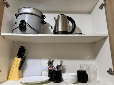 a shelf with a coffee pot and utensils on it at Room 643 Pool View Shore 2 Residences near PICC & SM MOA by Prime Stay in Manila