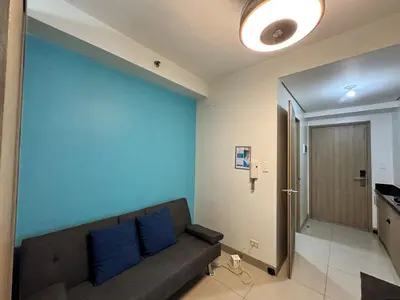 a living room with a couch and a blue wall at Room 643 Pool View Shore 2 Residences near PICC & SM MOA by Prime Stay in Manila