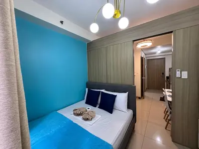 a bedroom with a blue wall and a bed at Room 643 Pool View Shore 2 Residences near PICC & SM MOA by Prime Stay in Manila