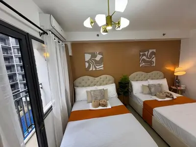 two beds in a small room with a window at 640 Coffee Room Shore 2 Residences MOA Pool View by Prime Stay in Manila