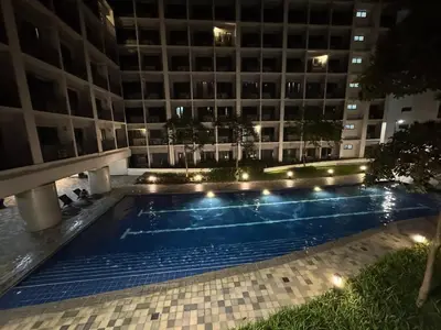 a swimming pool in front of a building at night at 640 Coffee Room Shore 2 Residences MOA Pool View by Prime Stay in Manila