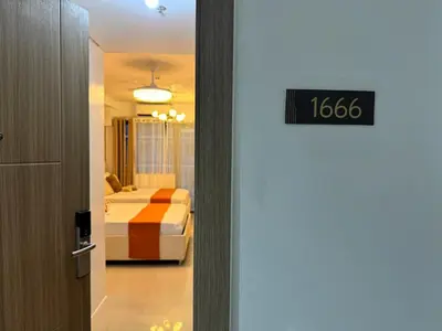 a door to a room with a bed and a bedroom at Coffee Room 1666 Shore 2 Residences Tower 1 Pool View by Prime Stay MOA in Manila