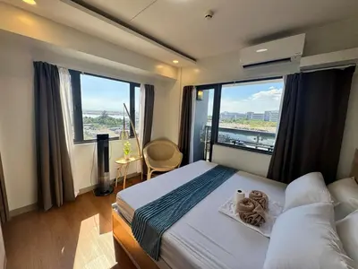 a bedroom with a large bed with a large window at 2BR facing Manila Bay & City View Shore 2 Residences MOA with Parking by Prime Stay in Manila