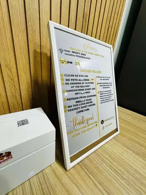 a menu board next to a white box on a table at 2BR facing Manila Bay & City View Shore 2 Residences MOA with Parking by Prime Stay in Manila
