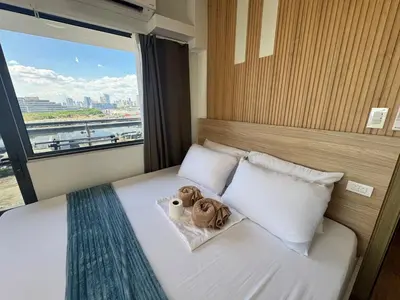 two teddy bears sitting on a bed with a window at 2BR facing Manila Bay & City View Shore 2 Residences MOA with Parking by Prime Stay in Manila