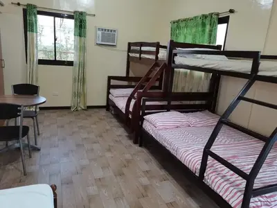 a room with three bunk beds and a table at Casa Ylaya - a New Private Pool Getaway in General Trias