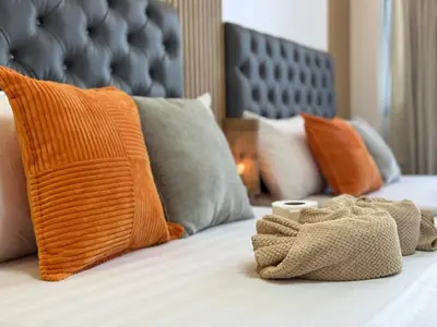 a bed with orange and gray pillows on it at Shore 2 Residences RM 19106 Pool View by Prime Stay MOA in Manila