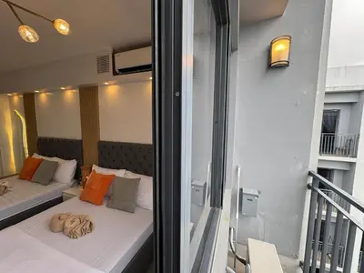 a bedroom with two beds and a balcony at Shore 2 Residences RM 19106 Pool View by Prime Stay MOA in Manila