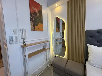 a room with a bed and a couch and a mirror at Shore 2 Residences RM 19106 Pool View by Prime Stay MOA in Manila