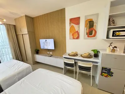 a bedroom with a bed and a table with chairs at Shore 2 Residences RM 19106 Pool View by Prime Stay MOA in Manila