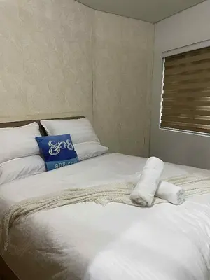 a bedroom with a bed with a towel on it at Suite A Deluxe Near SM MALL OF ASIA in Manila