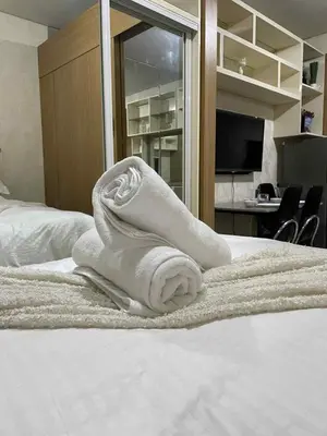 a towel sitting on top of a bed at Suite A Deluxe Near SM MALL OF ASIA in Manila