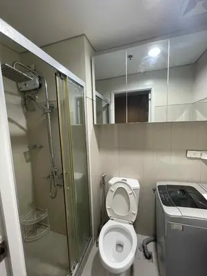a small bathroom with a toilet and a shower at Suite A Deluxe Near SM MALL OF ASIA in Manila