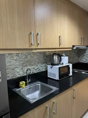 a kitchen with a sink and a microwave at Suite A Deluxe Near SM MALL OF ASIA in Manila