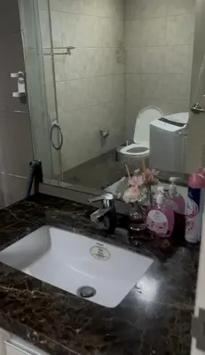 a bathroom counter with a sink and a toilet at H Cloud Suites Monarch Parksuites near MOA and Casino City in Manila