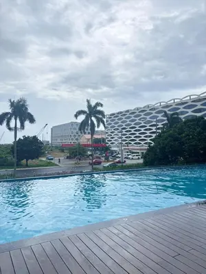 a swimming pool in front of a large building at H Cloud Suites Monarch Parksuites near MOA and Casino City in Manila