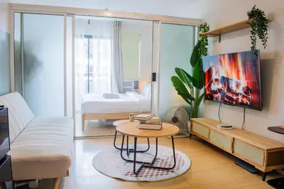 a living room with a couch and a table at Cozy Oasis Free pool, netflix, playground in Manila